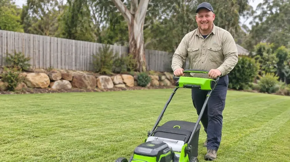 John from Beg Your Garden pushing a lawn mower across a freshly mown lawn in Ipswich QLD